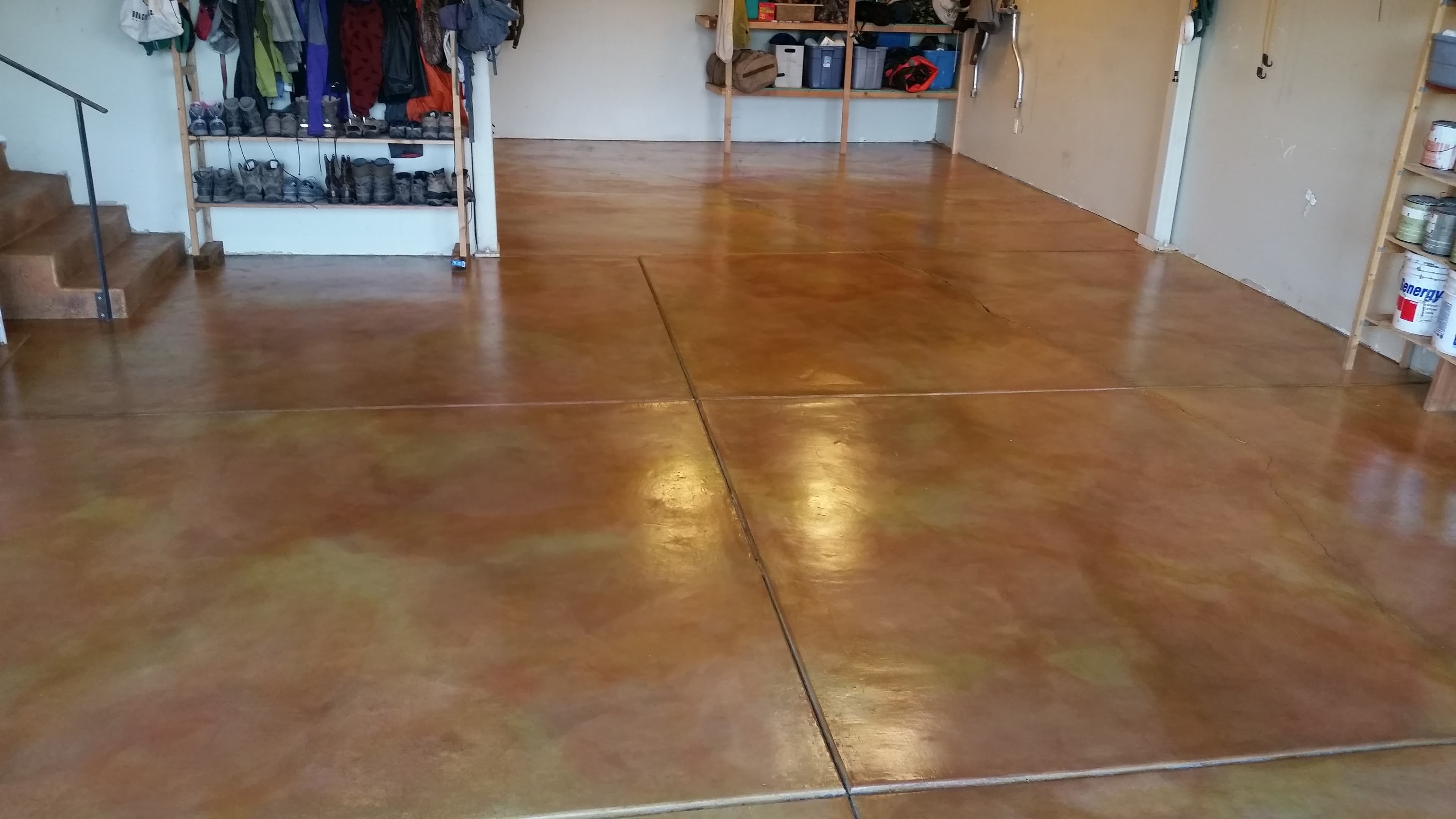 Residential garage with a warm layered stained-concrete floor completed by Bella Rocca