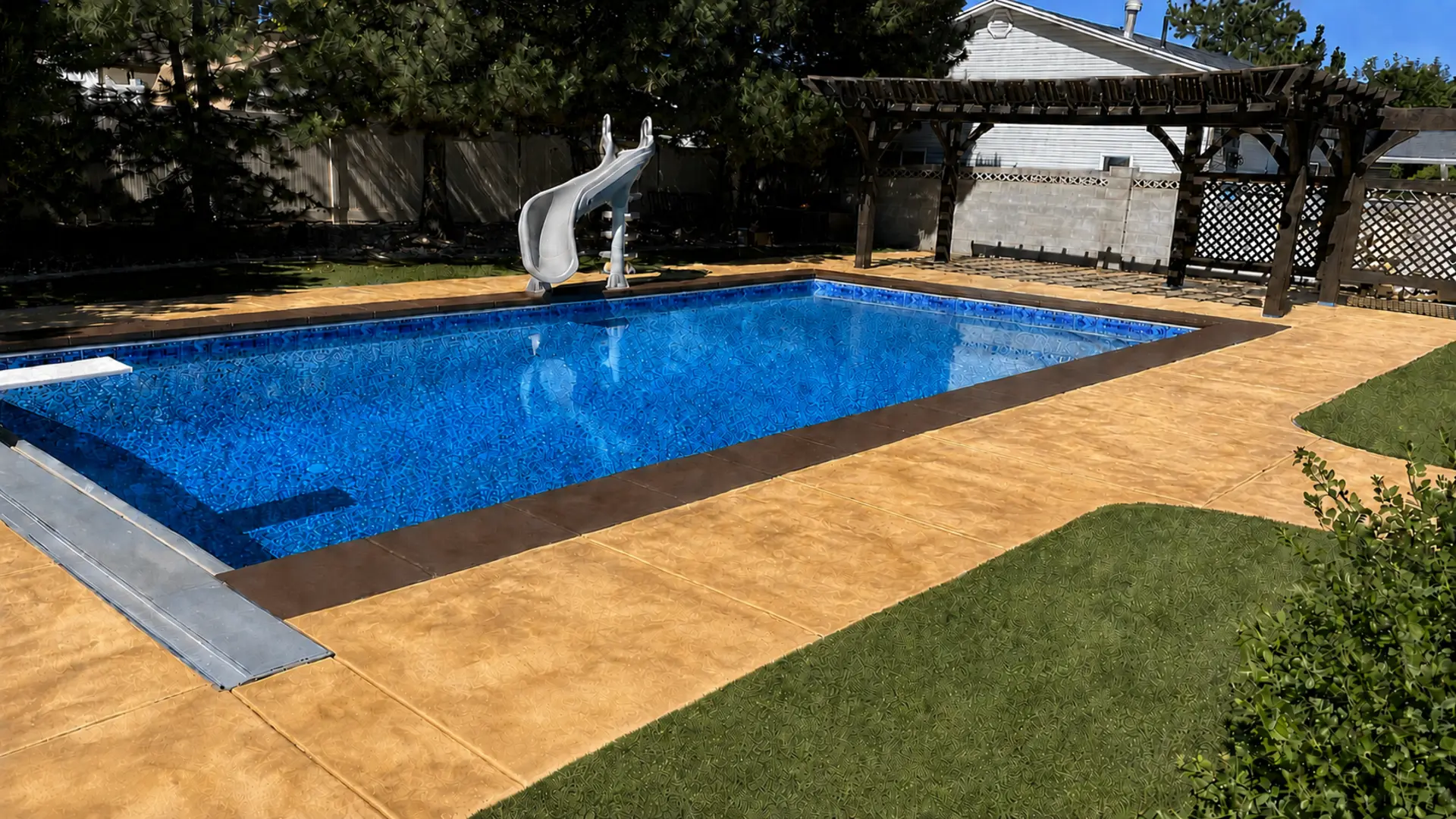 Completed decorative pool deck surrounding an open blue swimming pool