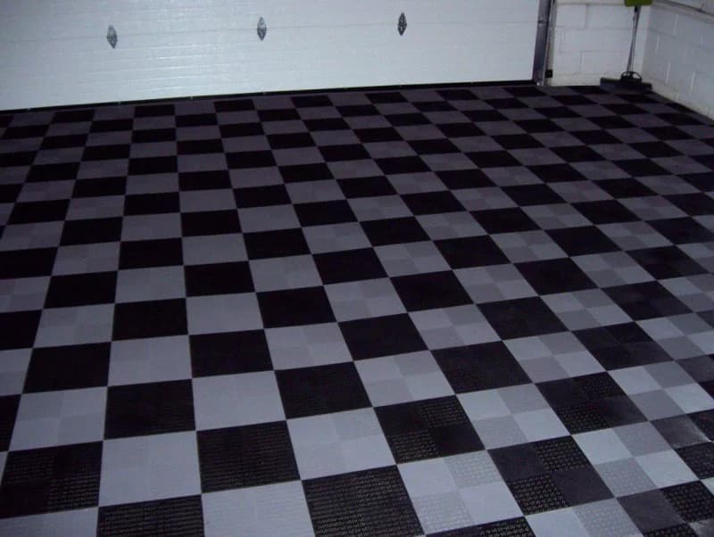 Black and white open-profile modular garage flooring in a finished garage